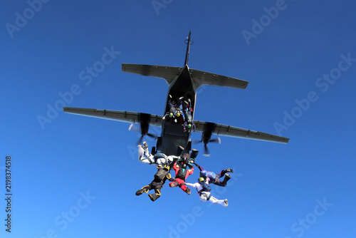 Skydivers jumping from a CASA C-212 aircraft.