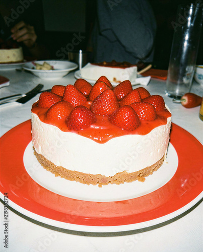 Delicious strawberry cheesecake red plate restaurant table
