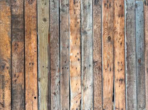 Rustic weathered wooden planks in varied natural brown, gray and beige tones forming a textured vintage background.