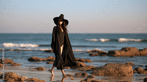 Woman in hat walking on beach