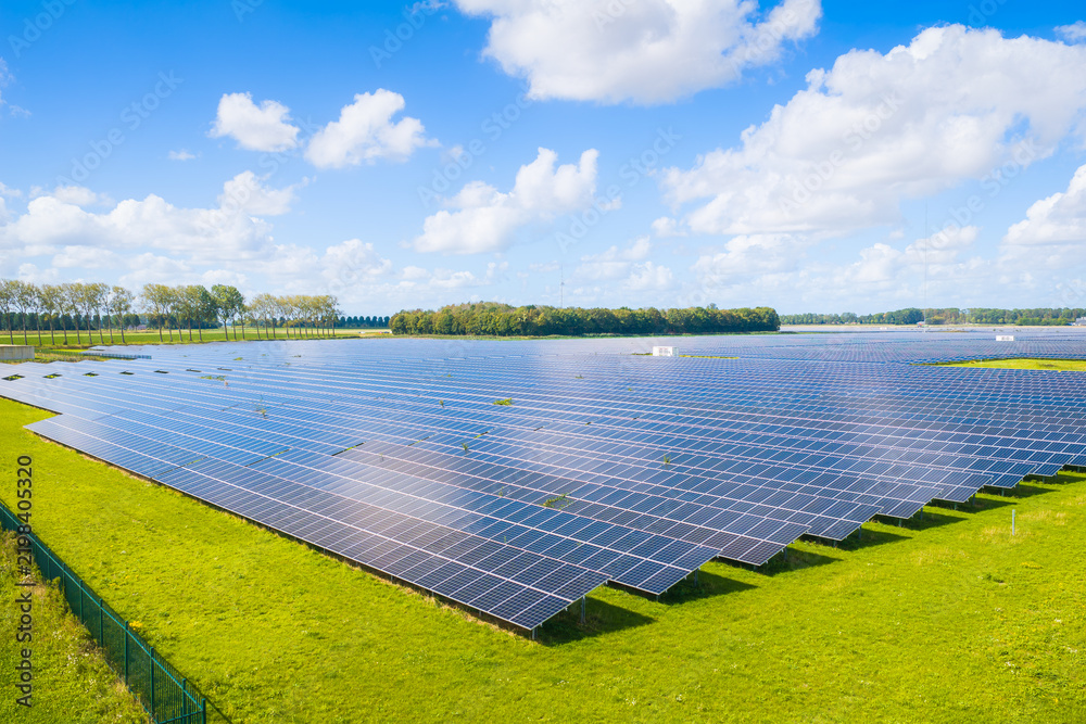Obraz premium Aerial drone view of solar panels in a renewable energy farm. Sustainable green power station for clean electricity production and environmental technology infrastructure.