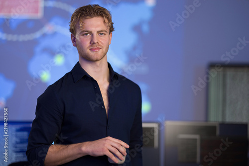 Male Engineer Working in a Control Room with Digital Map Display