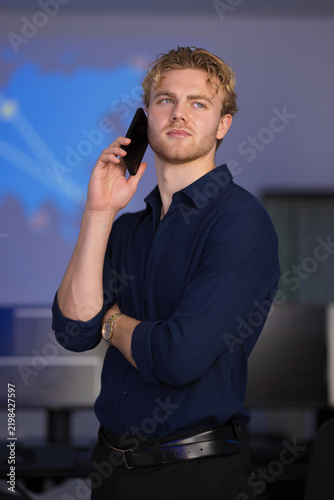Young professional on phone in modern office setting during strategic discussion