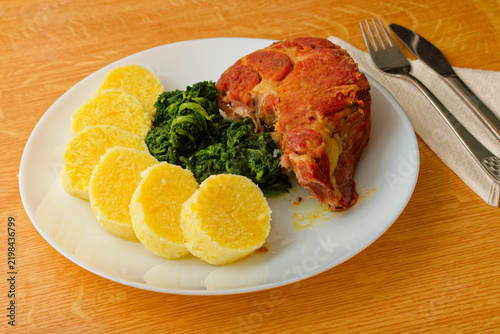 Czech food pork meat with potato dumpling and spinach