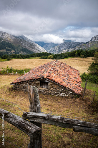 Cloud covered peaks above a rural countryside valley