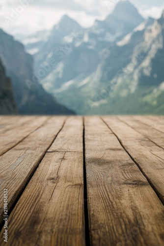 A wooden floor with mountains visible in the background vertical frame