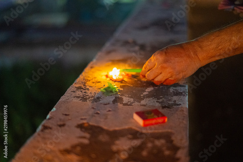 Close up of man's hand lighting candle with matches for fireworks on the indian festival of diwali