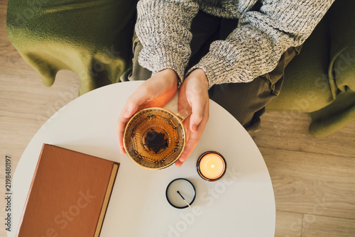 Фотография Cozy evening ritual with tea, candle and book