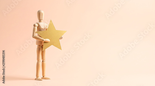 Marketing team mid year performance review and employee evaluation concept with wooden mannequin holding gold star rating with copy space for KPI tracking presentation banner
