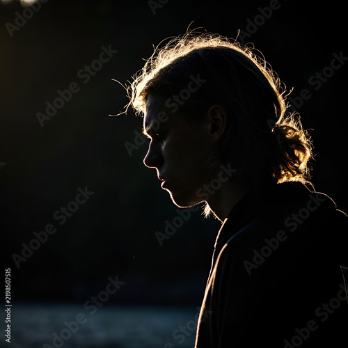 A dramatic side profile with a glowing outline, mysterious atmosphere.