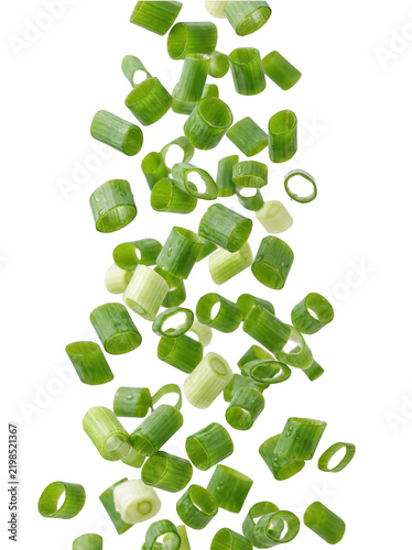 Dynamic high-speed action shot of fresh green onion rings falling and floating, perfectly isolated on a solid black background, creating a vibrant culinary composition with crisp textures and bright.