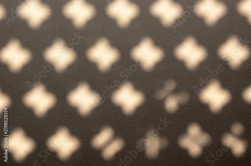 a wall on which a shadow is cast, forming a pattern of geometric shapes