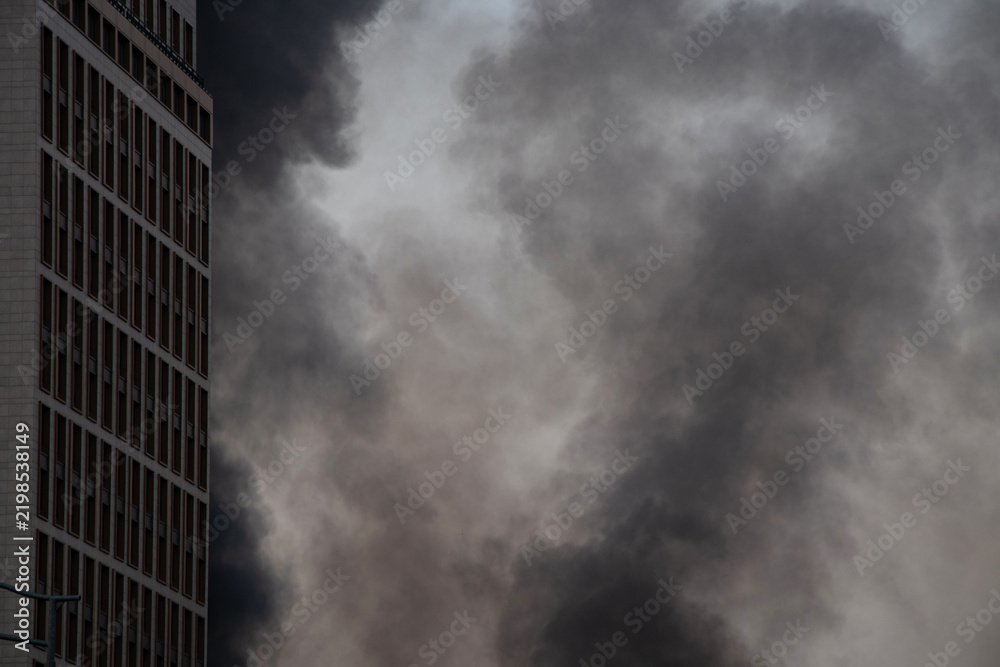 Obraz premium Thick black smoke rises from the top of an apartment building after a drone attack in Ukraine. The concept of fire, missile attack, drone raid