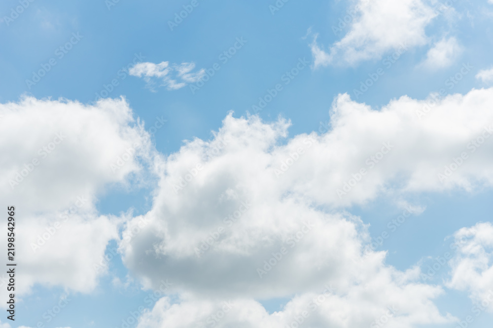 Fototapeta premium Fluffy white clouds against a bright blue sky background with copyspace for text