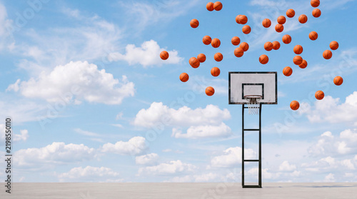 Basketballs soaring towards a hoop in a clear sky
