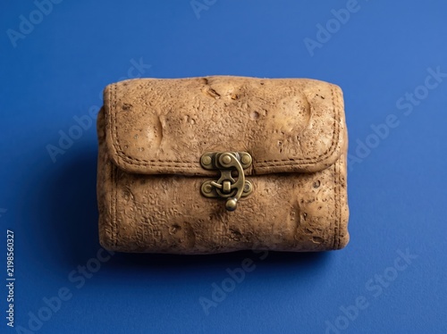 Potato shaped like vintage leather wallet on blue background