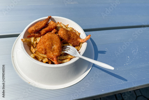 Obraz na plátně Delicious Fried Shrimp and French Fries Served in a Bowl on a Blue Picnic Table