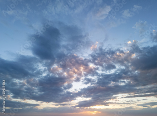 Plakat Cloudy sky during sunset over a landscape