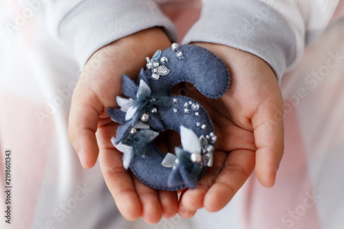 Child Hands Holding Blue Felt Number Six Decorated with Beads