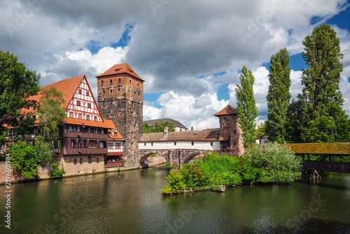 View of the historic timber-framed Weinstadel and Henkersteg bridge crossing the Pegnitz river in Nuremberg city, Germany.