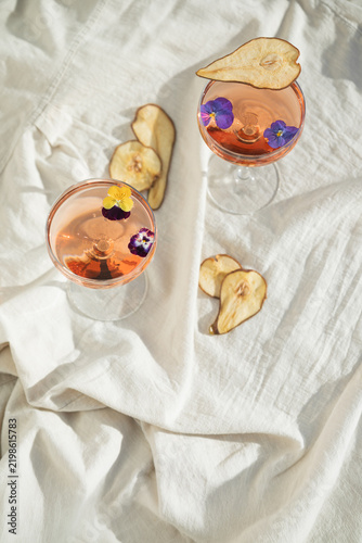 Two rose wine glasses on white fabric top view. Summer cocktails