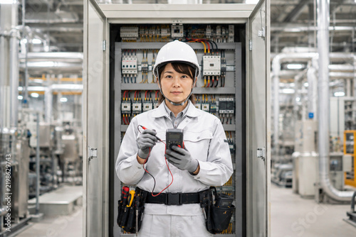 Plakat 工場で配電盤を点検する女性電気工事士