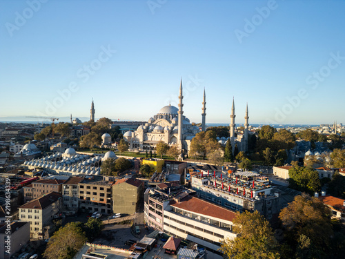 Bild auf Leinwand Turkey, Istanbul 06 10 2025: Side aerial drone photo of centered Suleymaniye Mosque at sunrise with Suleymaniye Salis Medresesi and Mimar Sinan roof top restaurant in foreground