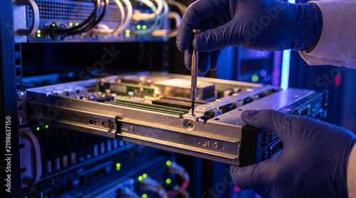 Professional technician securing server component for focus and efficient hardware maintenance in modern data center server room