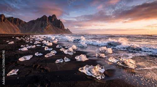 Ice chunks on black sand beach at sunset in iceland
