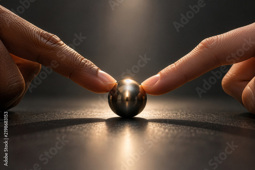 Balanced Metal Sphere Between Two Fingertips