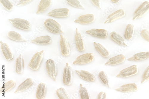 Obraz na plátně Shelled sunflower seeds scattered evenly on white background pattern