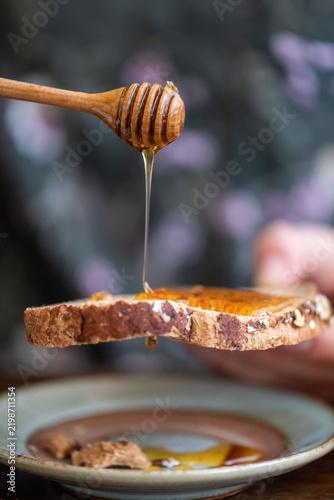 Картината върху платно Honey drizzling on rustic bread.