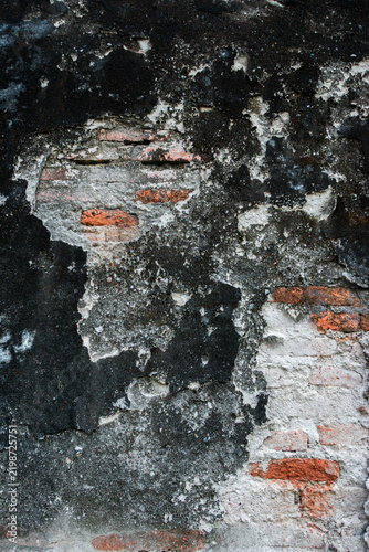 Foto A close-up view of a large crack in the wall of an old building, revealing the brickwork beneath; suitable for themes involving building damage or dilapidation