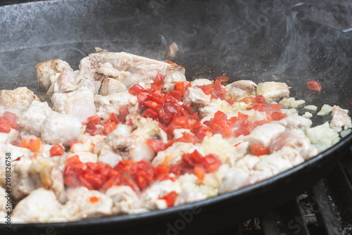 Картината върху платно Spanish Rice Simmering in Traditional Paella Pan