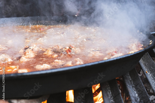Картината върху платно Spanish Rice Simmering in Traditional Paella Pan
