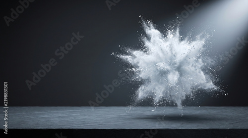Powder snow explosion over dark stone surface creates dramatic frozen burst under spotlight