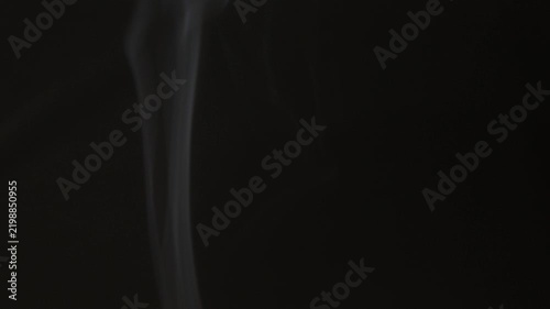 White smoke billows gently against a dark background.