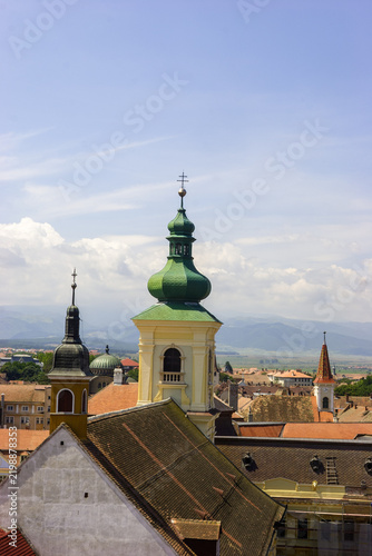 Obraz na plátně A view of church towers and rooftops in a European city on a sunny day