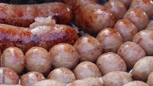 Close up video footage of thai sausage sizzling on charcoal grill, cooking thai street food isaan sausage.