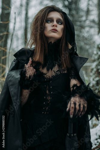 Mysterious witch walks in night forest. fog smoke, haze.Goth scary queen