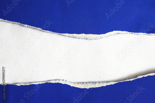A torn piece of white paper on a blue background