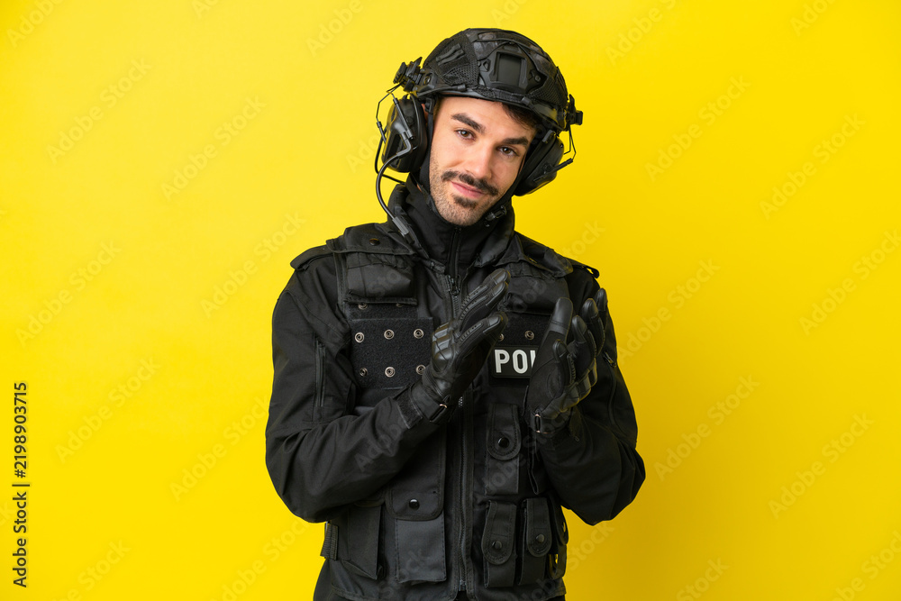 Fototapeta premium SWAT caucasian man isolated on yellow background applauding after presentation in a conference