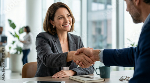 Businesswoman and Man Shaking Hands at Office Meeting, Partnership Agreement
