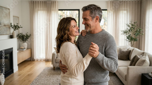 Happy couple dancing at home, enjoying romantic moment in modern living room