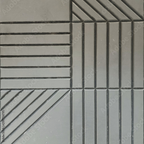 Close-up of geometric textured concrete wall tile with diagonal and parallel lines pattern