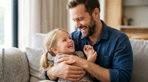 Father Laughing With Daughter on Sofa - Happy Family Moment