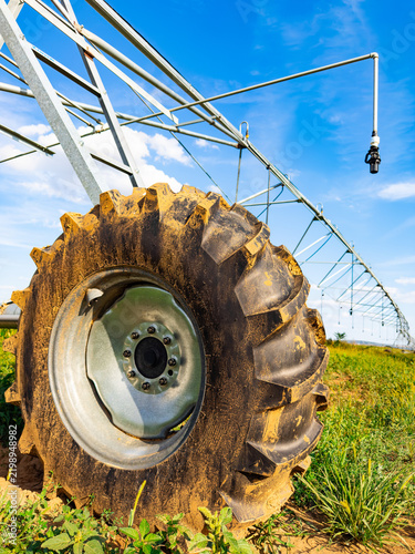 Fotografie Pivot irrigation wheel and hanging sprinkler nozzle in field