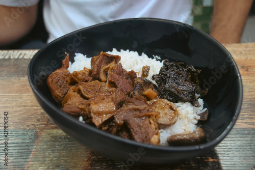 Obraz na płótnie Braised beef (Ngau Lam) with chu hou paste, fermented spinach and rice in a black bowl, traditional local Cantonese dish served in street side food stall called dai pai dong