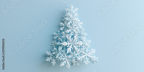 A Christmas tree shape created with delicate snowflakes on a light blue background, evoking winter and the holiday season
