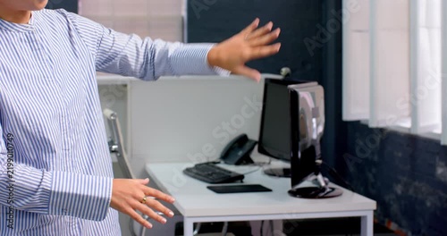 Business professional gesturing in modern office near computer and desk